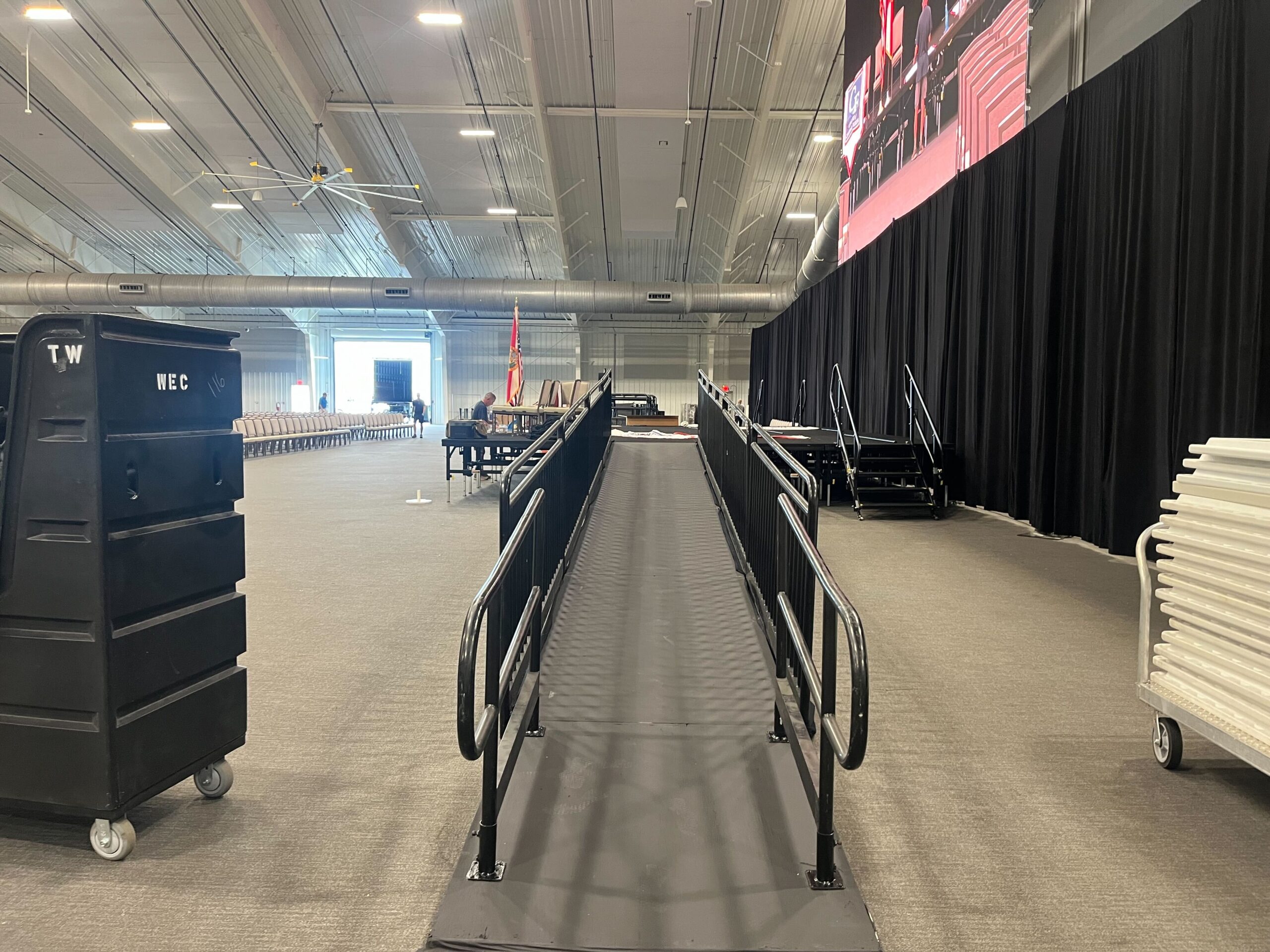 Stage teardown in Orlando showing ramp sections and guard rail components being disassembled by crew, March 2026