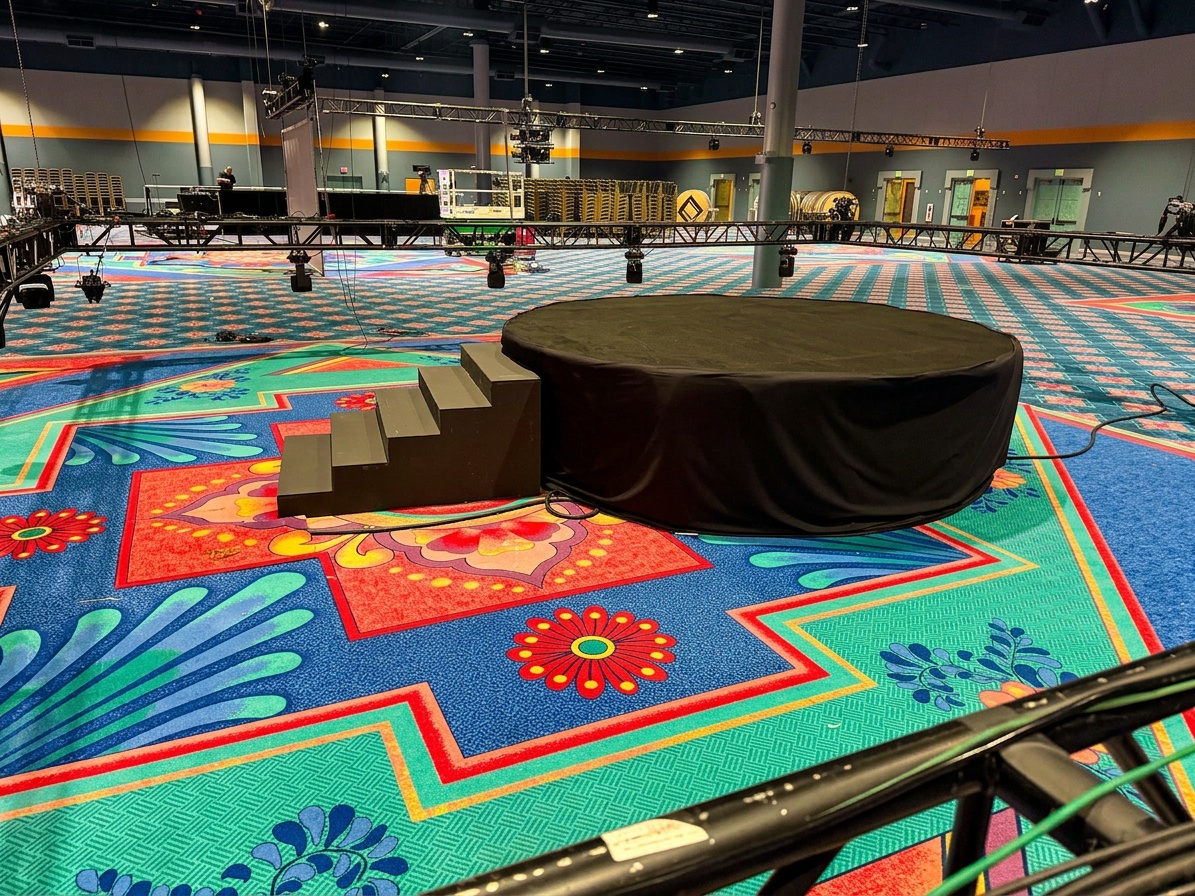 circular stage deck set up outdoors with audience chairs arranged in a full circle around it