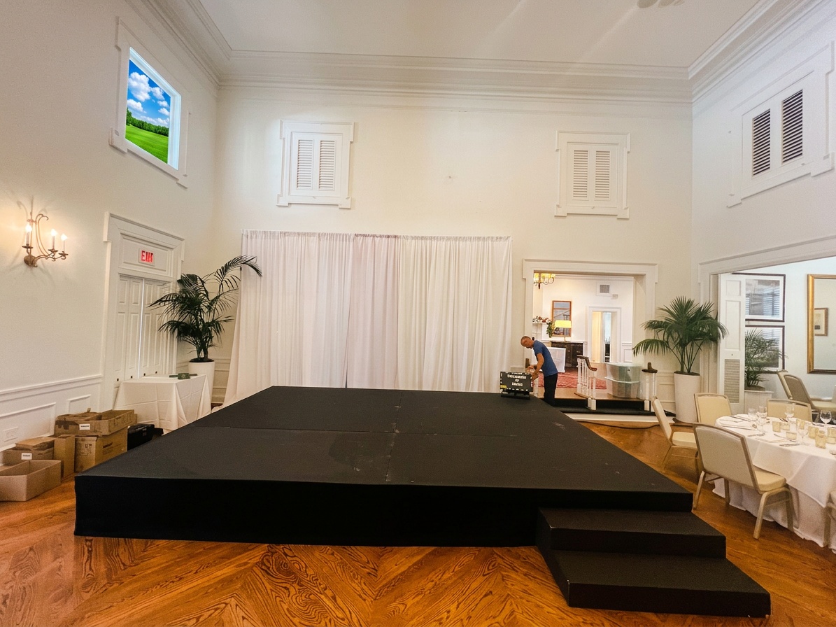 crew measuring ceiling clearance in a ballroom before stage setup