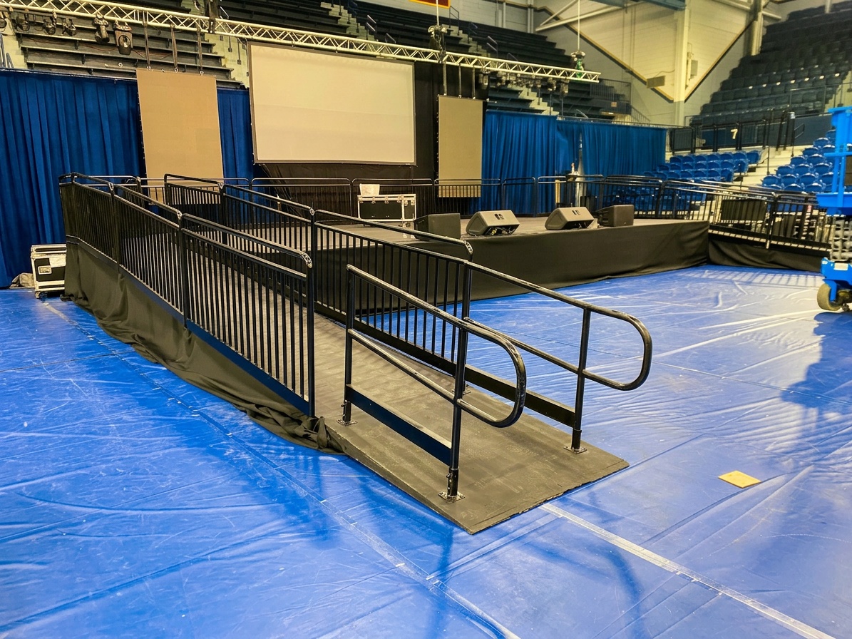 wheelchair-accessible seating area with clear floor space marked near a stage front