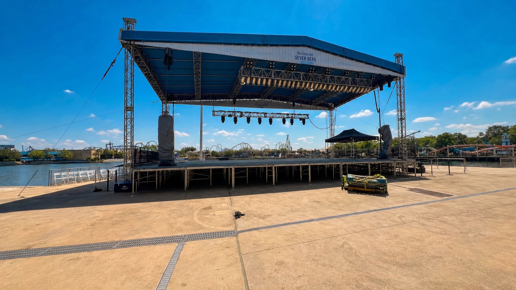 stage crew resetting drum kit on a side riser during a live band changeover