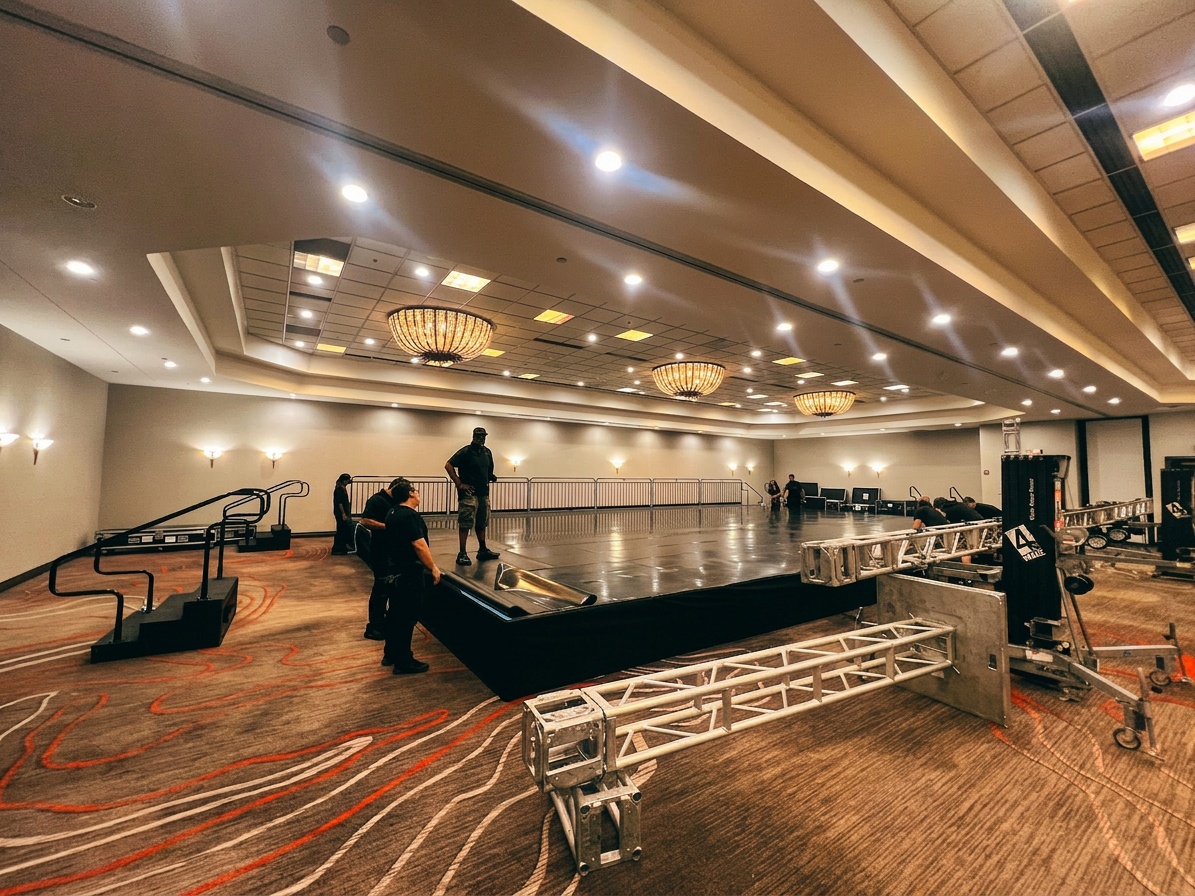 two-person crew assembling pipe and drape frame at an indoor Winter Park event